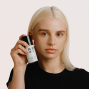 Person holding a bottle of Rope Skin product against a plain background